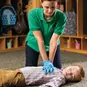 An adult performing CPR on a child.