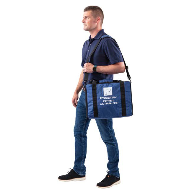 CPR instructor carrying the Prestan Infant Manikin in a blue carrying case with Prestan Infant Ultralite text on the bag.