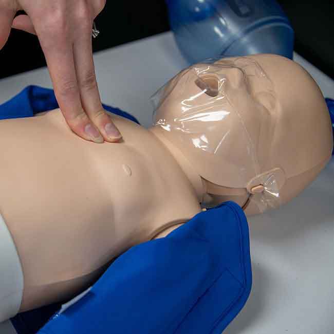 Student practicing CPR compressions on a Prestan Infant Manikin.