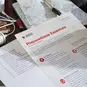 American Red Cross Preparedness Essentials Checklist next to an emergency phone number list, map and batteries.