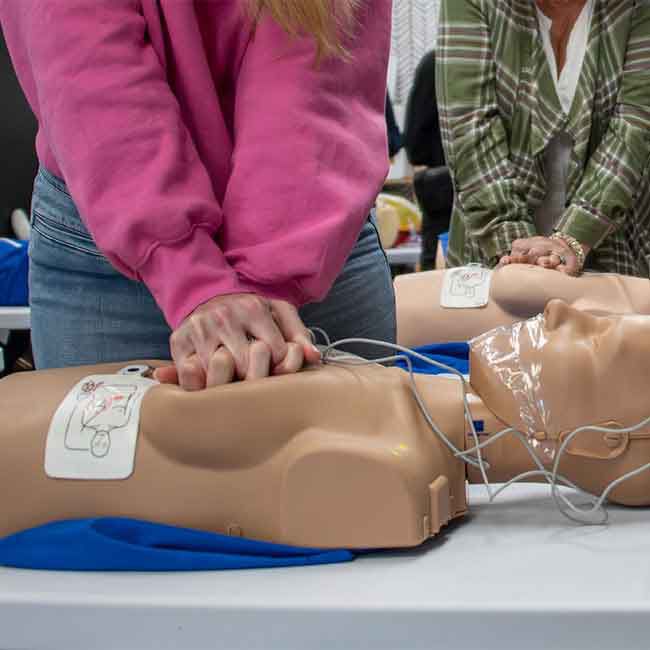 Students practicing CPR on Prestan Female Adult Manikins.