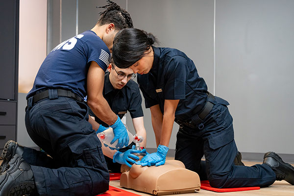 Three North Carolina EMS professionals practicing basic lifesaving skills on a female manikin.