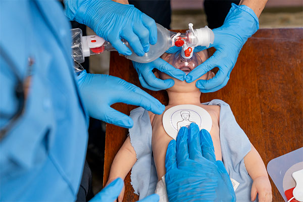 Healthcare professionals in Los Angeles, California practicing basic lifesaving skills on an infant manikin.