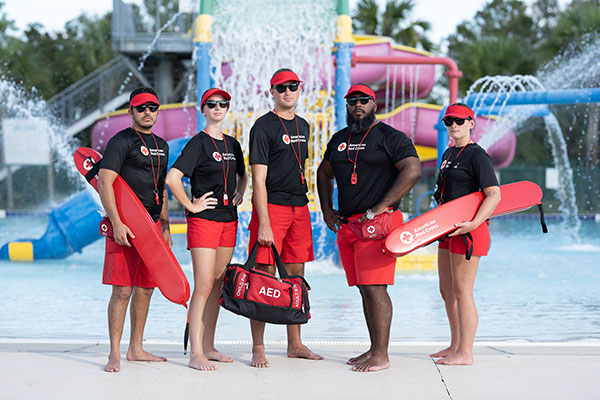 Five Red Cross certified lifeguards with lifesaving equipment in California.