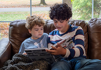 A babysitter reading a book to a child.