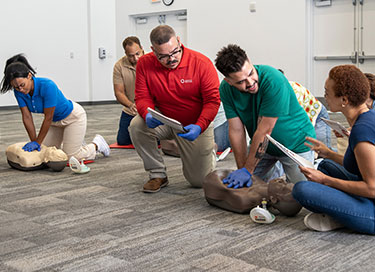 Employees and instructors participating in First Aid, CPR, and AED safety training from the American Red Cross.